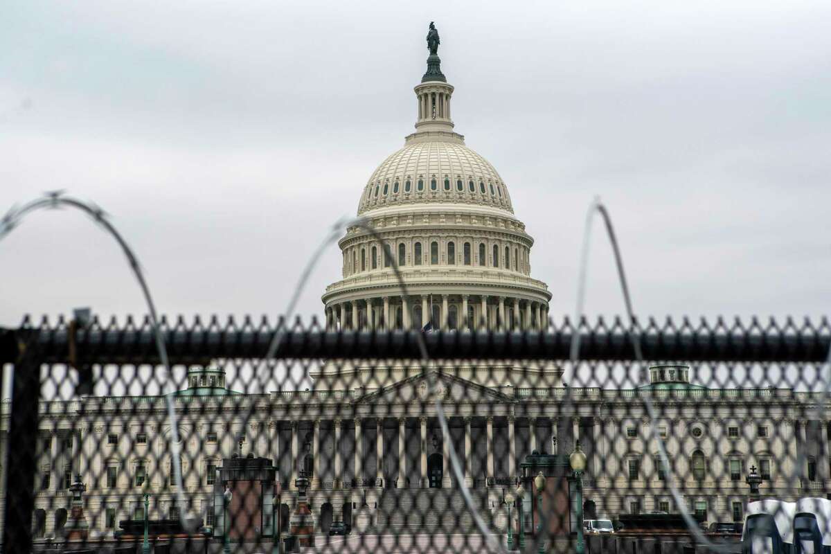 The U.S. Capitol is seen through a fence with barbed wire during the second impeachment trial of former President Donald Trump. (AP Photo/Jose Luis Magana)