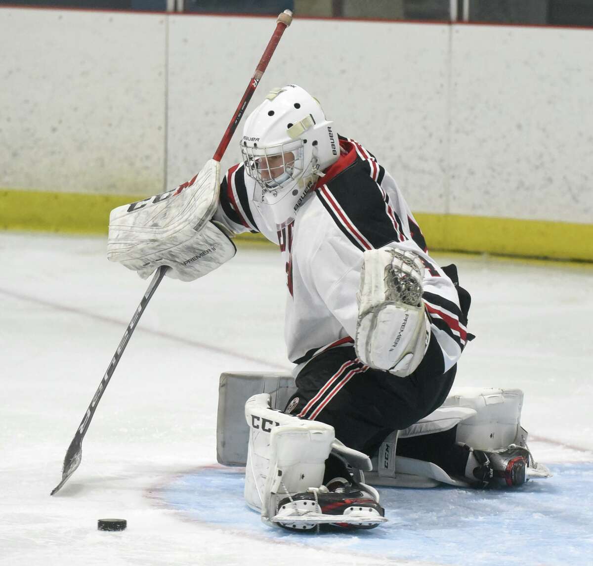 New Canaan goalie Beau Johnson makes a kick save during the Rams' boys ice hockey game against Ridgefield at the Darien Ice House on Saturday, Feb. 13, 2021.