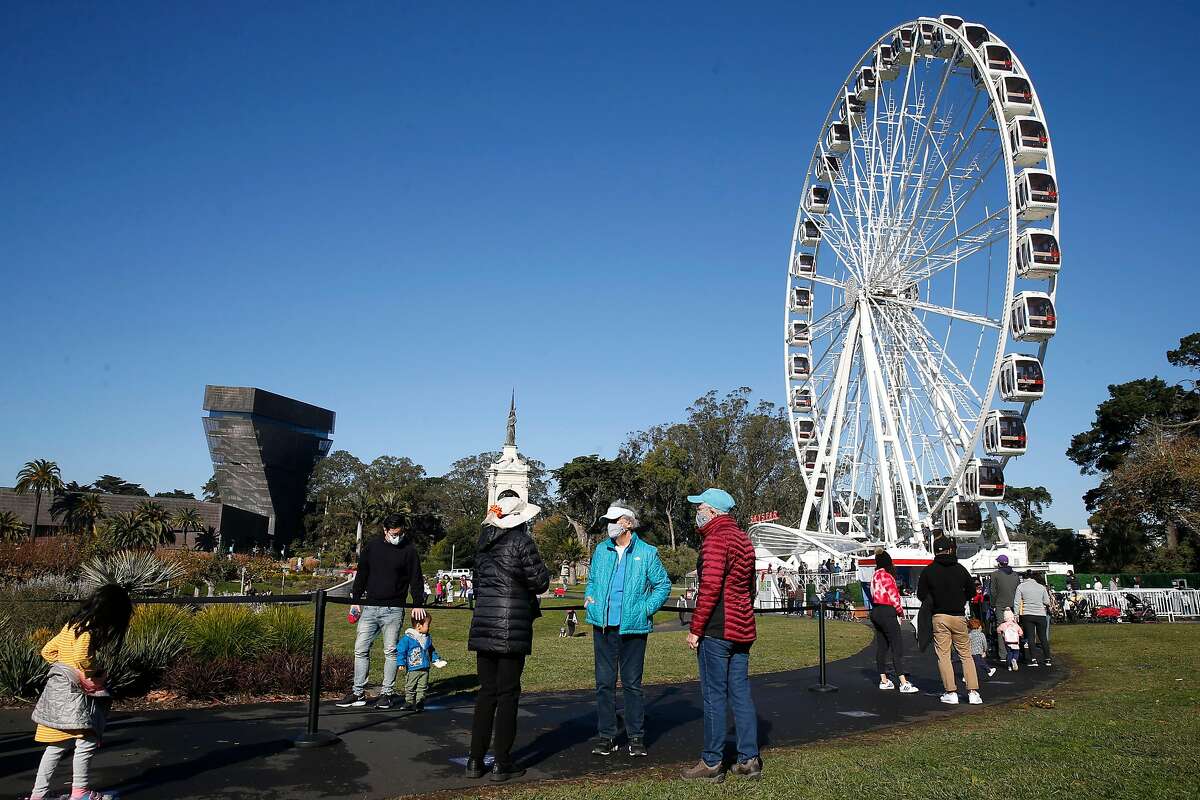 Visitors wear masks and maintain social distancing while waiting in line for a spin aboard the Skystar observation wheel at Golden Gate Park in November.