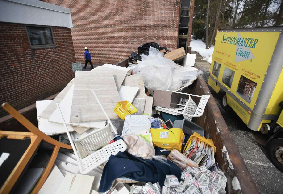 Water-damaged ceiling tiles and other items fill a dumpster behind North Mianus Elementary School after flooding this weekend caused by a frozen and burst second floor pipe in Greenwich, Conn. on Sunday, February 14, 2021.
