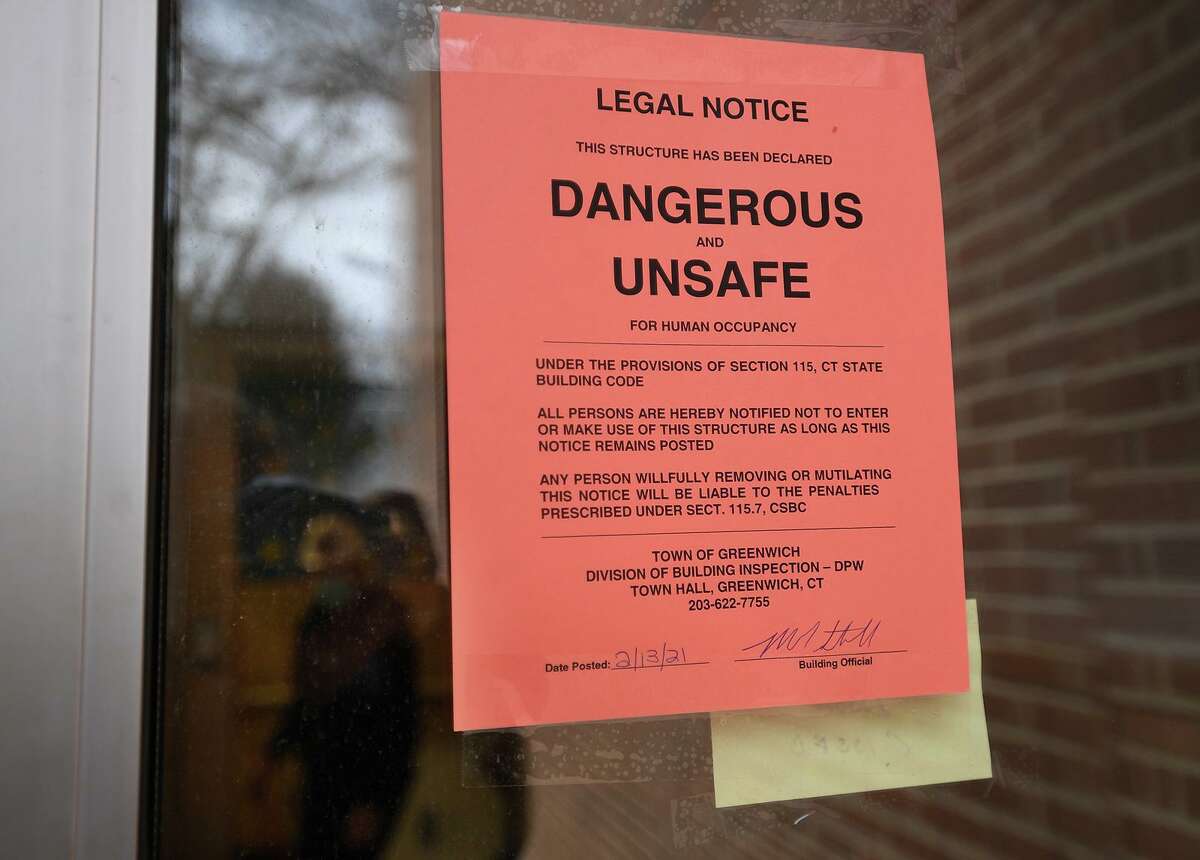 Signs posted on the doors of North Mianus Elementary School following this weekend's flooding caused by a frozen and burst second floor pipe in Greenwich, Conn. on Sunday, February 14, 2021.