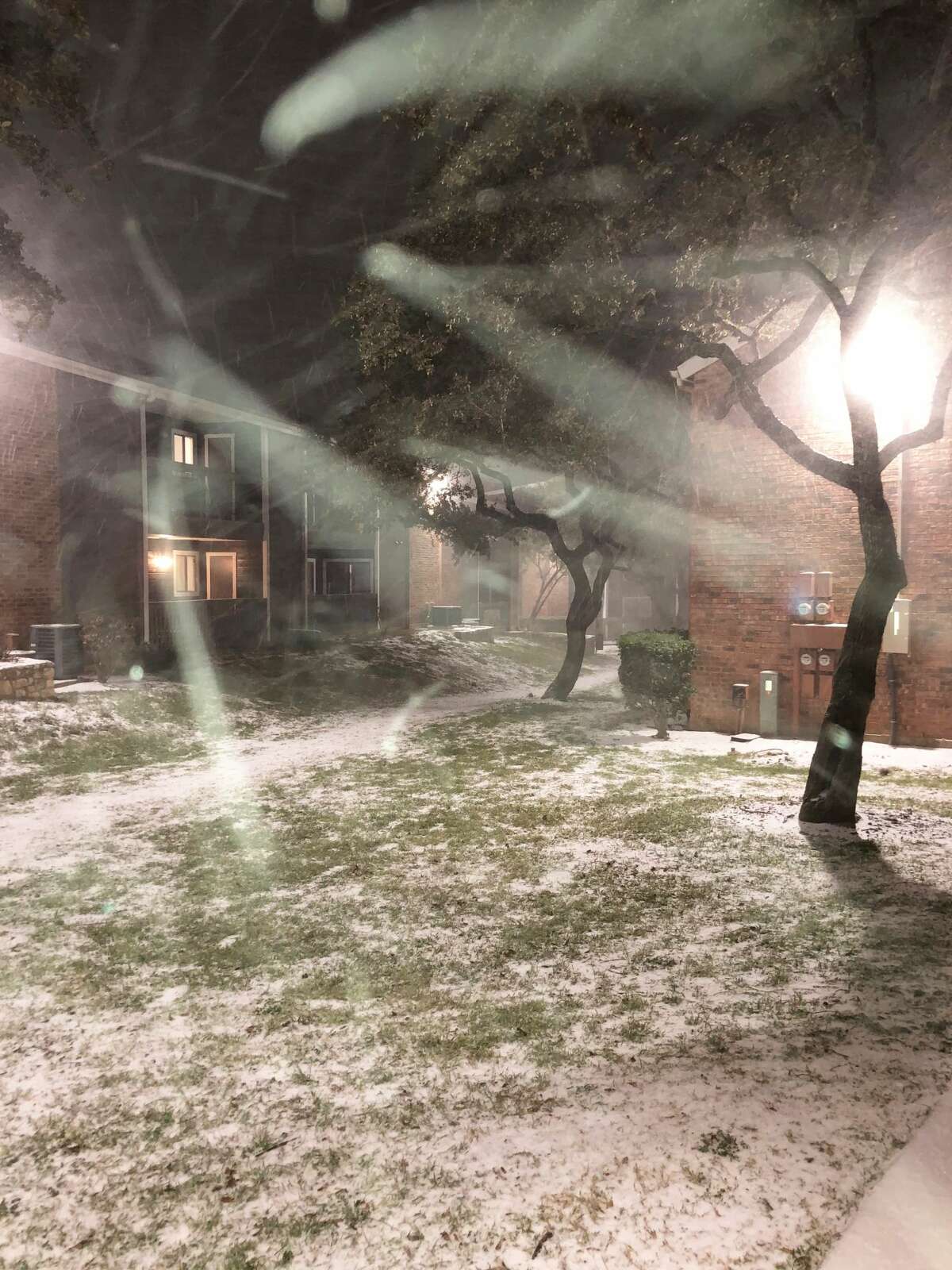 Snow falls at a North Side San Antonio apartment complex Sunday night, Feb. 14, 2021.