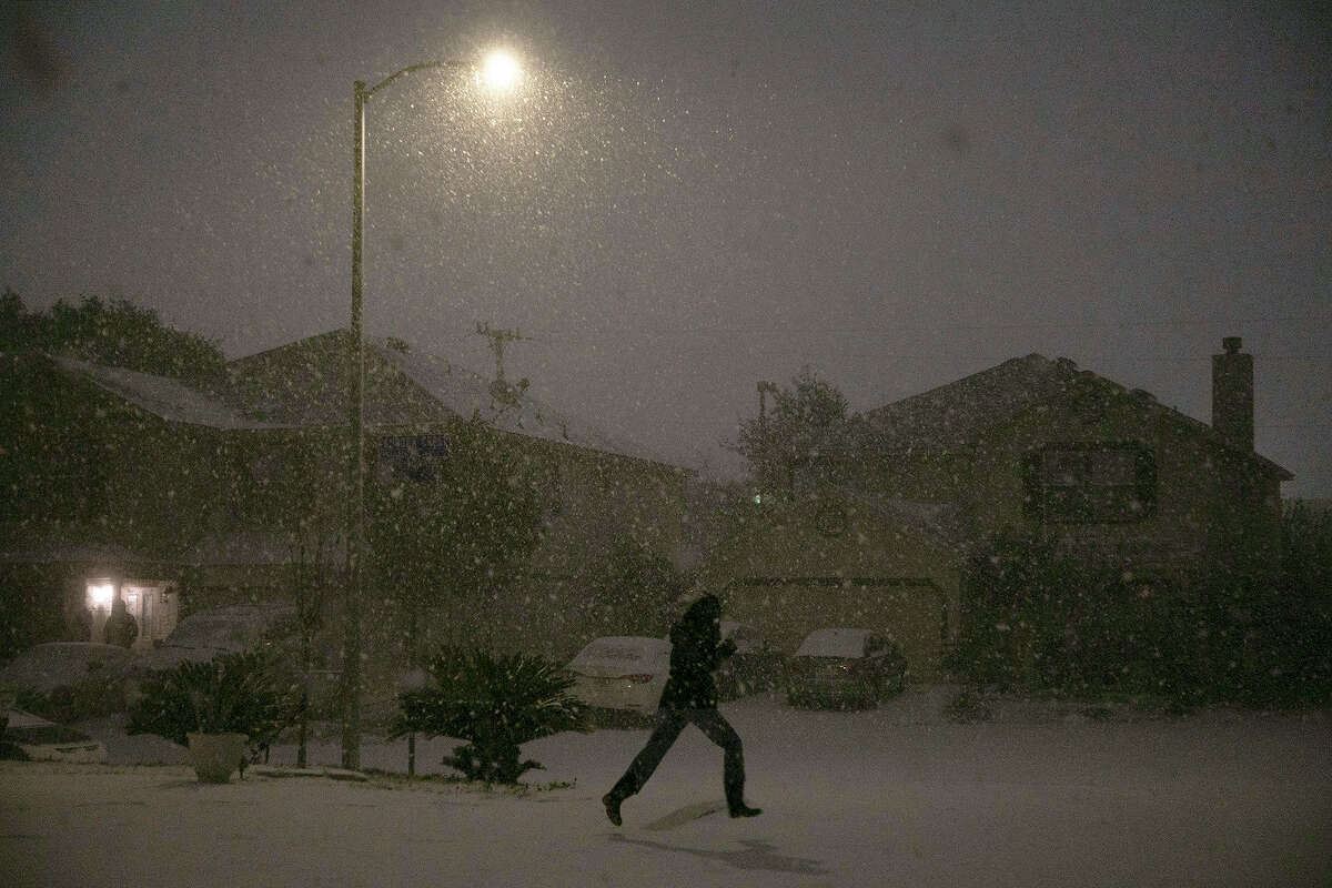 Georgina Rodriguez, 13, runs through the snow late Sunday night, Feb. 14, 2021, in San Antonio.