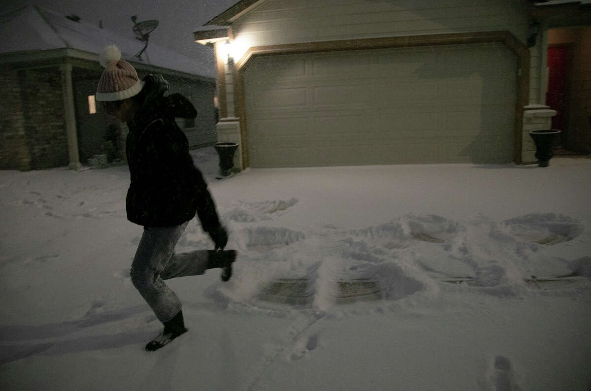 Georgina Rodriguez, 13, runs away from her freshly made snow angel to not disturb it late Sunday night, Feb. 14, 2021, in San Antonio.