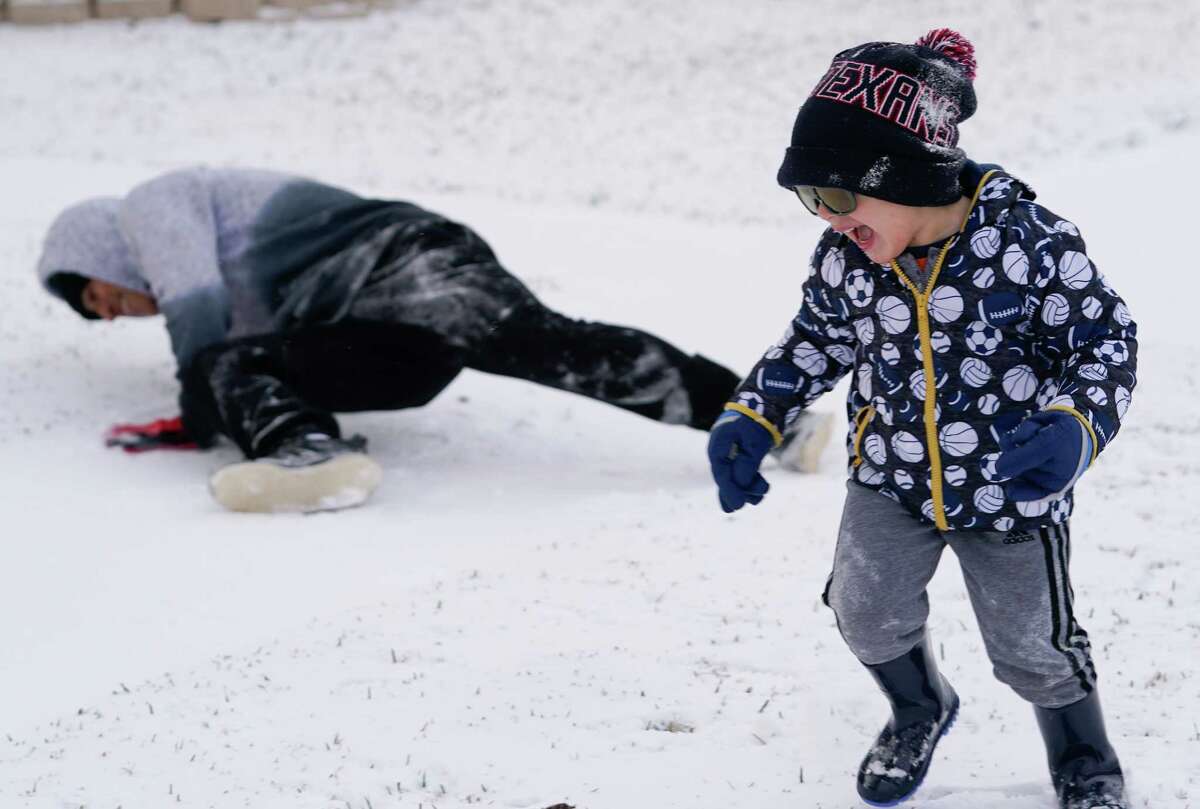 Roberto Sanchez, 18, plays in the snow with his brother, Santi Sanchez, 3, during the arctic storm Monday, February 15, 2021 in Houston.