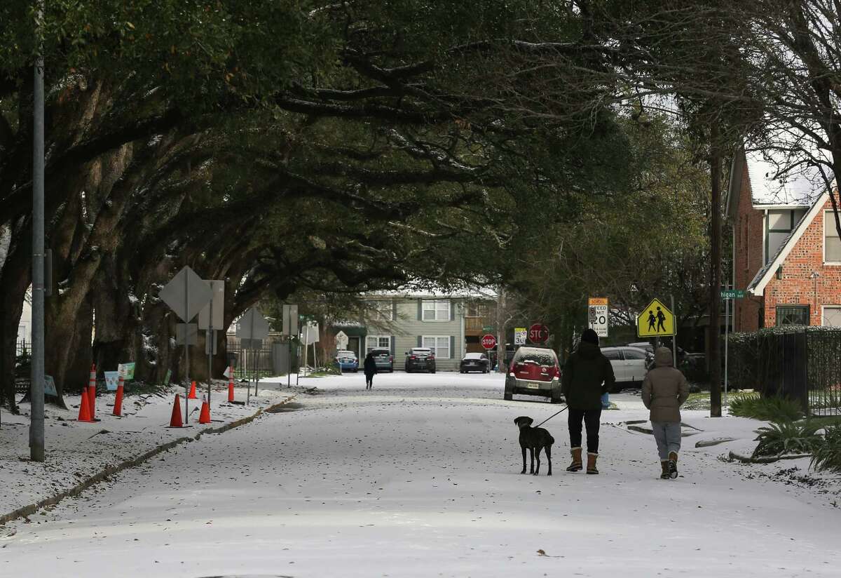 People walk around their neighborhood to check out snow Monday, Feb. 15, 2021, at Montrose in Houston.