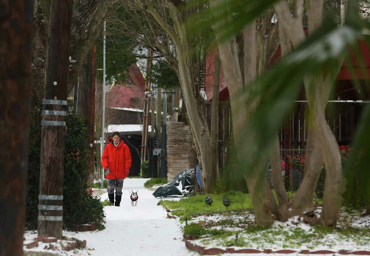 People walk around their neighborhood to check out snow Monday, Feb. 15, 2021, at Montrose in Houston.