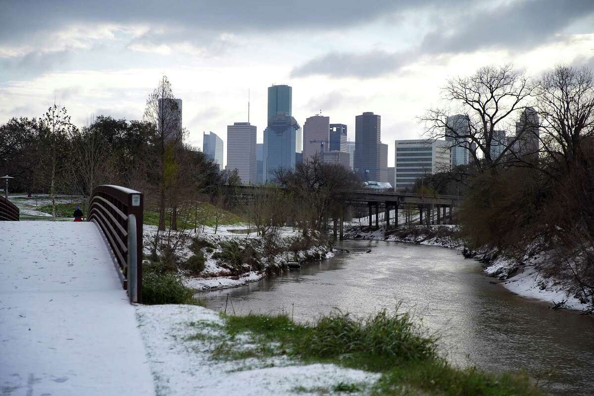 Snow accumulates along the Buffalo Bayou in Houston on Monday, Feb. 15, 2021.