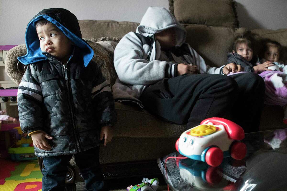 Eithan Colindres wears a winter coat inside after the apartment his family lives in lost power following an overnight snowfall Monday, Feb. 15, 2021 in Spring. Temperatures plunged into the teens Monday with light snow and freezing rain.