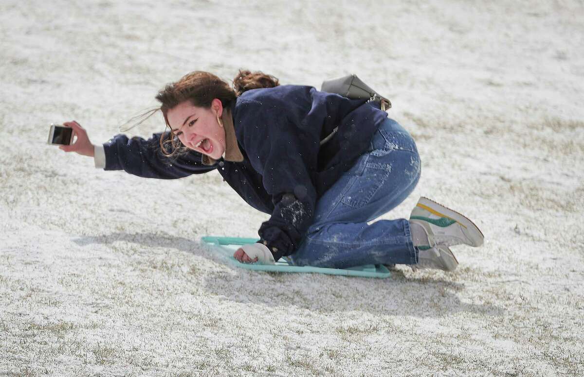 Rice University students Belen Szentes documents her sled ride on the Miller Outdoor Theatre hill Monday, Feb. 15, 2021, in Houston.