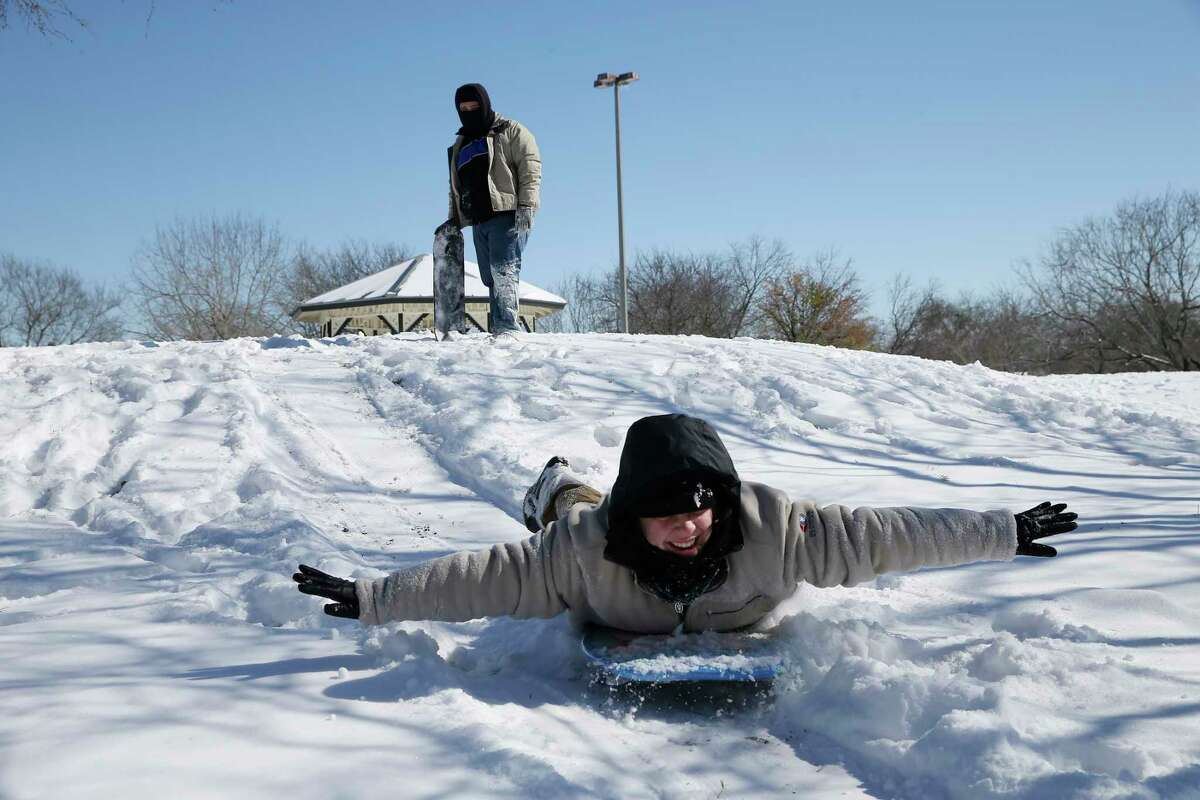 Olivia Zapata, 15, in front, and her brother, Josiah, 18, play in the snow at the Heritage Duck Pond Park, Monday, Feb. 15, 2021.