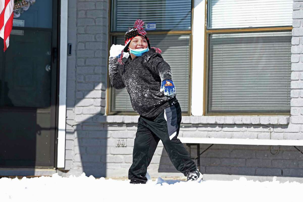 Nathanial Hernandez, 7, gets into a snowball fight with his family in the Heritage neighborhood, Monday, Feb. 15, 2021.