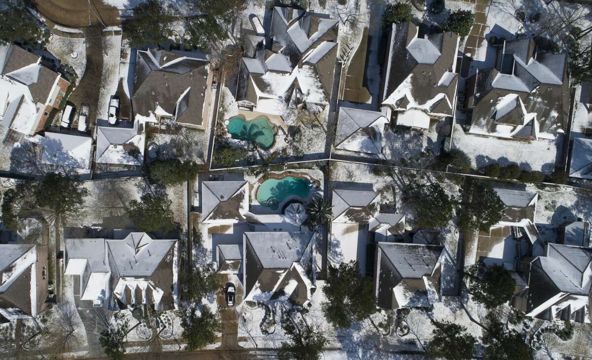 Snow and ice are seen on homes, Monday, Feb. 15, 2021, in Kingwood.