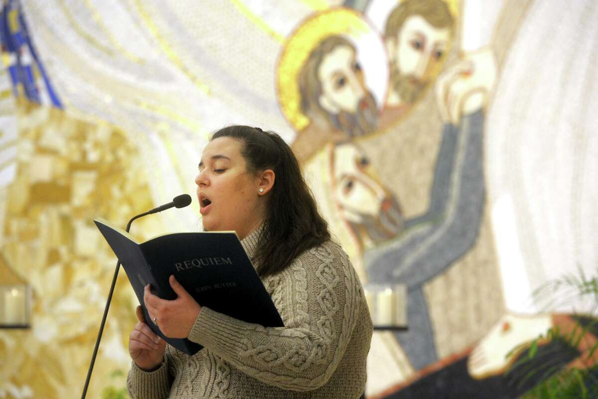 Student Michaela Vieira sings a hymn at the start of a COVID-19 memorial prayer service held in the Chapel of the Holy Spirit on the campus of Sacred Heart University, in Fairfield, Conn. Feb. 15, 2021.