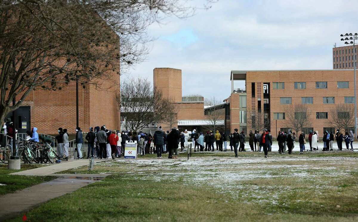 People line up to receive the COVID vaccine at Rice University in Houston on Monday, Feb. 15, 2021. Officials said 1,000 doses of Moderna vaccine issued to the university must be used by 5 p.m. today, but inclement weather has dashed initial rollout plans. As a result, anyone on campus can go to the East Gym and get a dose on a first-come, first-served basis.