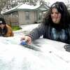 Jazmine Sanchez laughs as Daniela Uresti uses a spoon and small brush to try and scrape the ice from her vehicle as Southeast Texans awoke to frigid temperatures and iced cars and roadways Monday as the arctic front moved in overnight. Photo taken Monday, February 15, 2021 Kim Brent/The Enterprise
