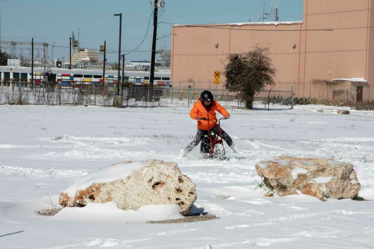 Samuel Martinez, 8, rides his motor bike through the snow near the Hayes Street Bridge 15, 2021. Temperatures dropped to record lows Sunday night and will stay dangerously low Monday night as well.