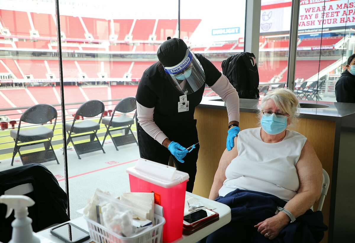 April Green, a nurse, administers a coronavirus vaccine at Levi's Stadium in Santa Clara, Calif., on Tuesday, Feb. 9, 2021. The United States, facing a growing threat from more contagious and possibly deadlier virus variants, is gradually administering more doses every day, now up to an average of about 1.7 million as of Sunday night, according to a New York Times database. (Jim Wilson/The New York Times)