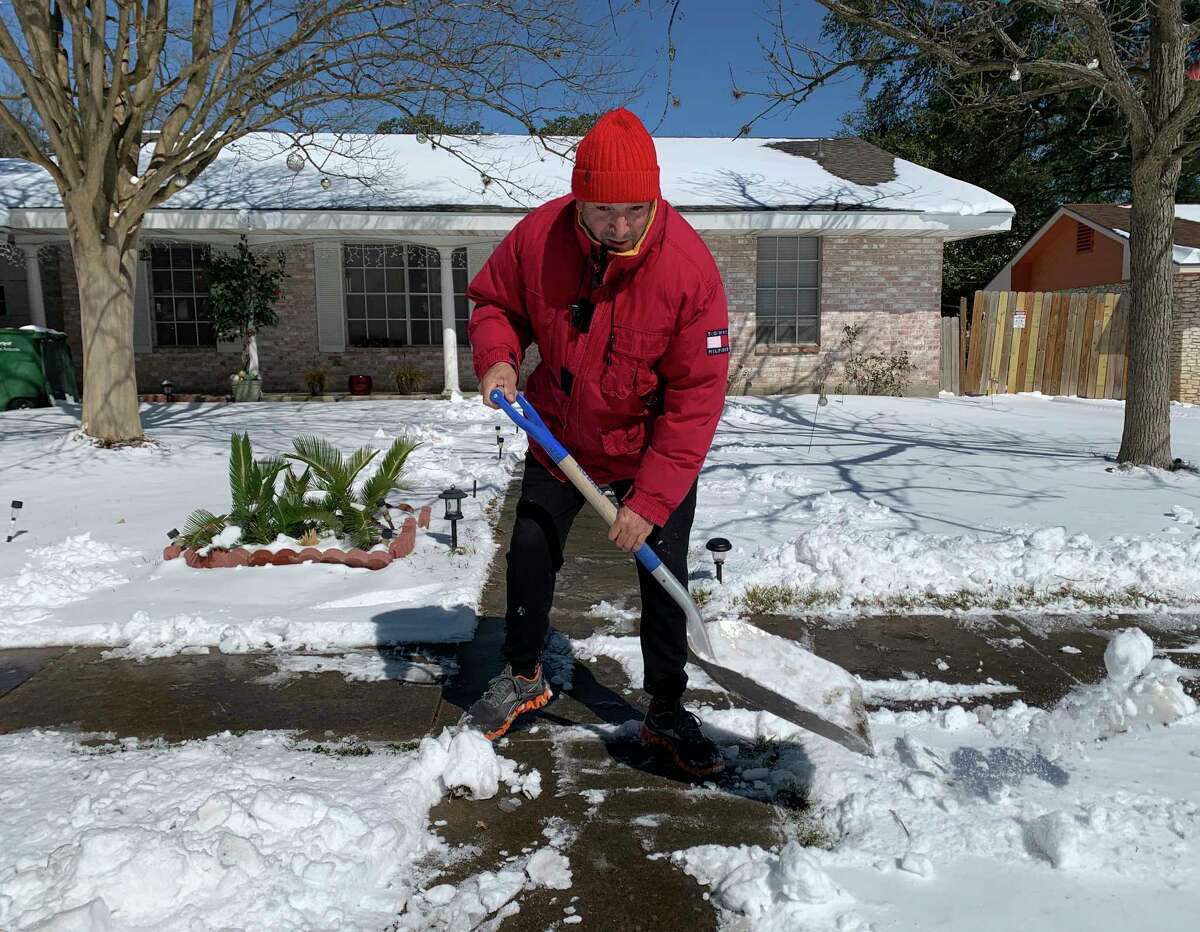 Saul Cortez shovels snow from the sidewalk in front of his home in the Harmony Hills neighborhood on Monday, Feb. 15, 2021, after inches of snow fell overnight. He said that he is from New Jersey, where the snow that fell in San Antonio would be considered a mild annoyance.