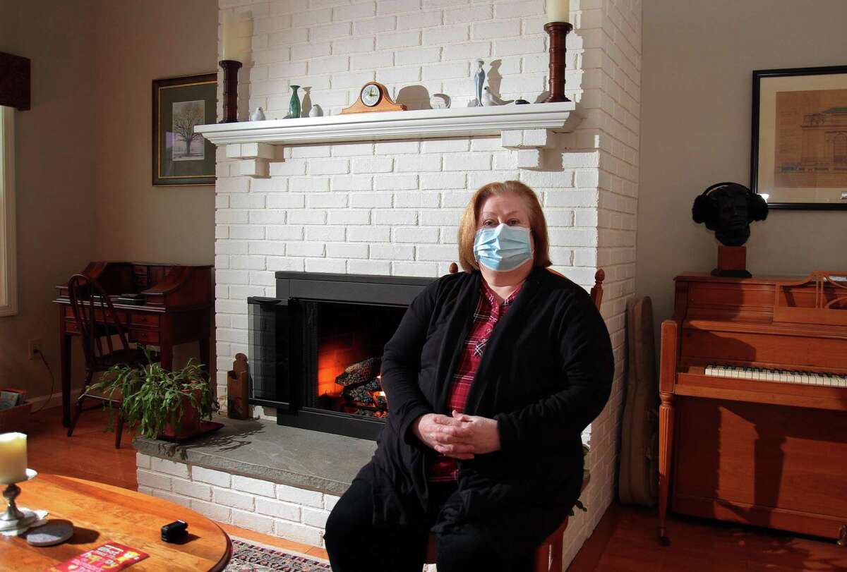 Joan Stokes, who is recovering from COVID-19, poses in her home in Woodbury on Saturday. The Shelton Library, where Stokes works as director, has been closed since several staffers tested positive, many who were hospitalized including one who died. Stokes spent 12 day in the hospital.