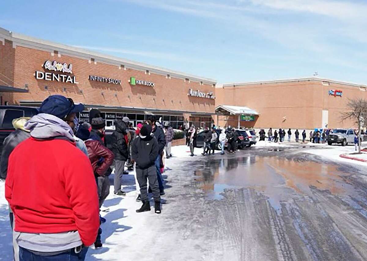 People wait in line at a mall to get inside an H-E-B supermarket in Round Rock, Texas, on February 16, 2021. Millions were left without power as a deadly winter storm gripped the southern and central United States Tuesday. Hardest hit was Texas, where freezing conditions prompted utility companies to implement rotating blackouts to stop the power grid being overloaded by the surge in demand.