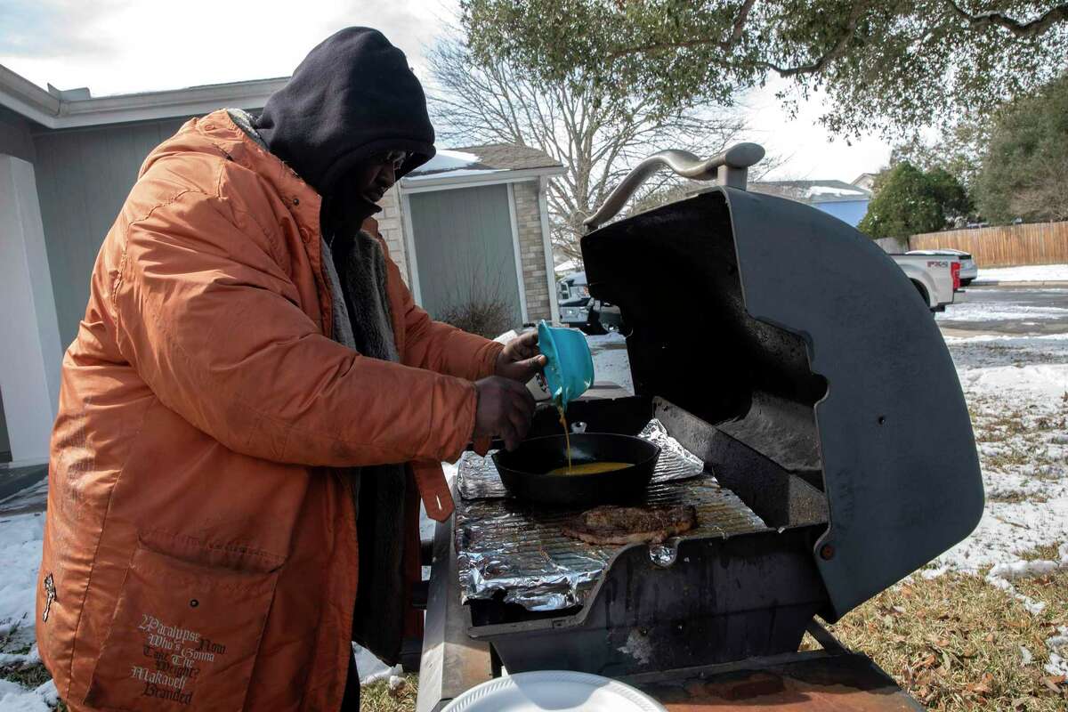 Damien Charles cooks brunch for his family outside his home on Tuesday. Charles’s water pipes broke and he and his family lost their power Tuesday morning. San Antonio has seen the lowest temperatures since 1989 this week.