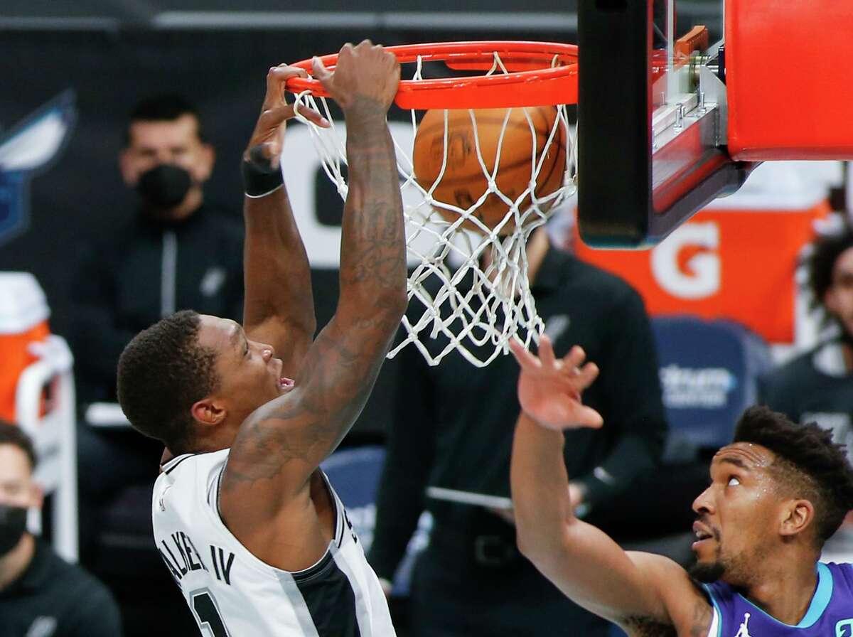 Lonnie Walker IV dunks on Charlotte’s Malik Monk in the Spurs’ 122-110 win Sunday. Walker went 5 of 7 for 11 points and impressed coach Gregg Popovich with his defense.