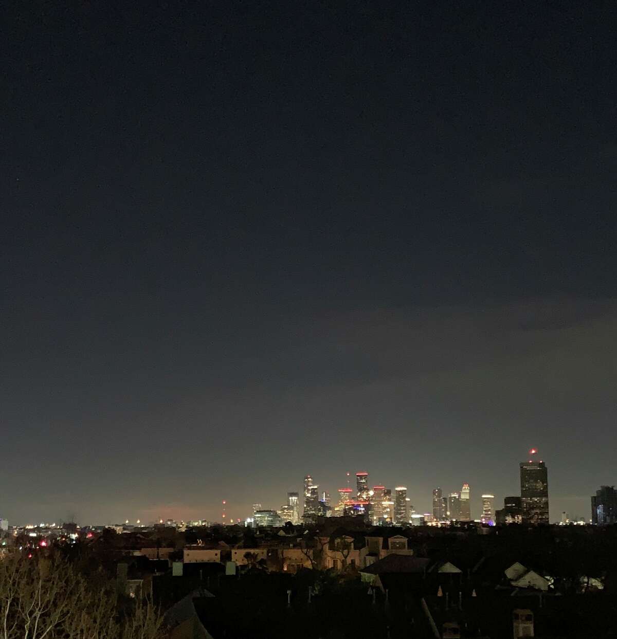 This photo posted on Twitter Monday night shows the Houston skyline lit up brightly while surrounding homes are in the dark.