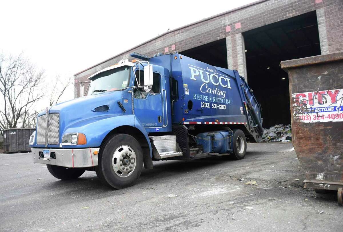 Trucks dump trash in the commercial dumping bay at the Holly Hill Transfer Station in Greenwich, Conn. Monday, Jan. 27, 2020. A sunset clause in the tipping fee that had been scheduled for the fall was moved to June 30, 2022 and remains likely to be eliminated entirely.