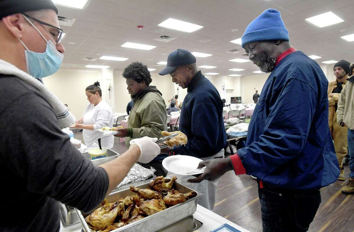 Billy Campbell serves chicken to Donald Bias as lunch is served at Victory Temple in Beaumont, which opened to those in need of shelter from the storm Saturday and will remain open through Friday morning. Bias has been living outside at the downtown bus station for three months sinnce completing his parole and having to leave the halfway house at which hhe had been staying. He suffers from multiple health conditions, has been running out of his medication, and receives only $265.00 a month from his railroad pension.