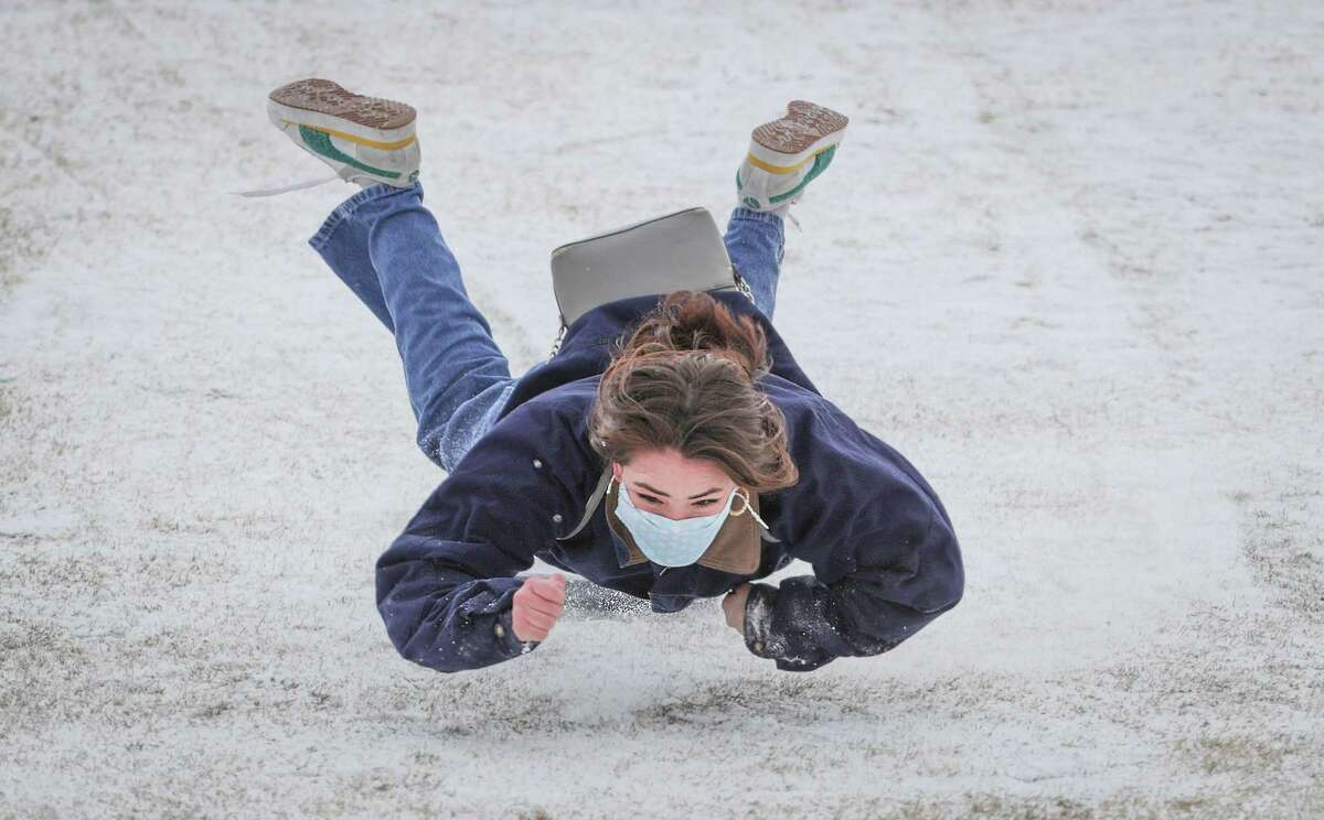 Rice University student Belen Szentes becomes airborne after her plastic bin lid stopped while she was sledding on the Miller Outdoor Theatre hill Monday, Feb. 15, 2021, in Houston.