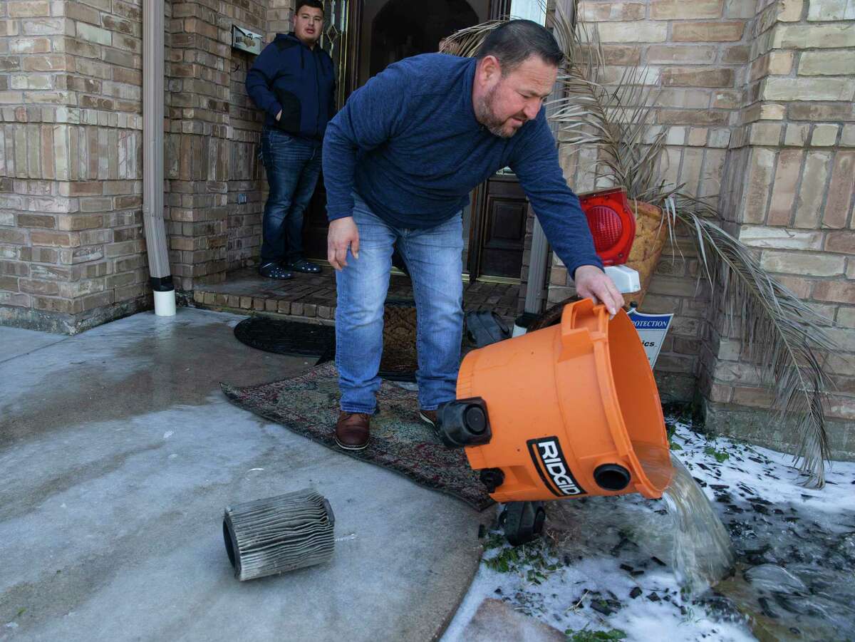 Jacob Chapa dumps water pumped out of his mother-in-law's house Tuesday, Feb. 16, 2021, in South Houston. Sylvia Gomez lost power at her house and went to stay with her daughter in Pasadena last night, but came home to find her water pipes bursted due to the cold weather and flooded her house. They had to rent a water suction pump to pump the water on the floor.