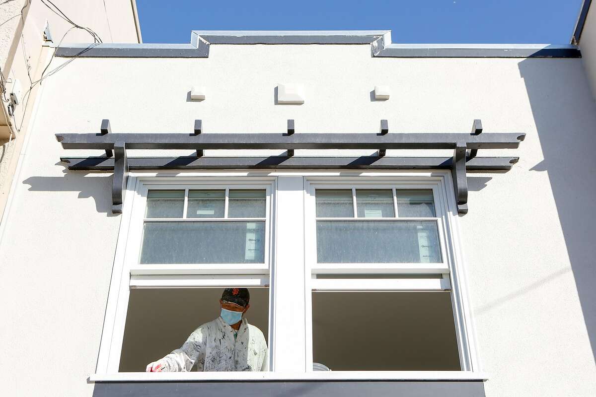 Yin Yang paints the interior of a single family home being renovated for sale in the Outer Sunset on Monday, October 26, 2020 in San Francisco, Calif.