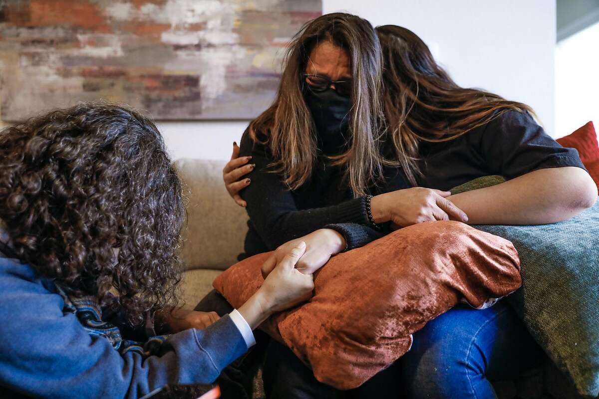 Diana Collins Puente (left) holds hands with sister-in-law Maria Cassandra Quinto-Collins and niece Isabella “Bella” Collins, 18, as they get emotional about the loss of son and brother Angelo Quinto who died in police custody in December on Wednesday, Feb. 17, 2021 in Antioch, California. Angelo Quinto died in Antioch police custody in December and the police did not alert the public about the in-custody death. The family says that the officers placed their knees on his neck for over four minutes until he died.