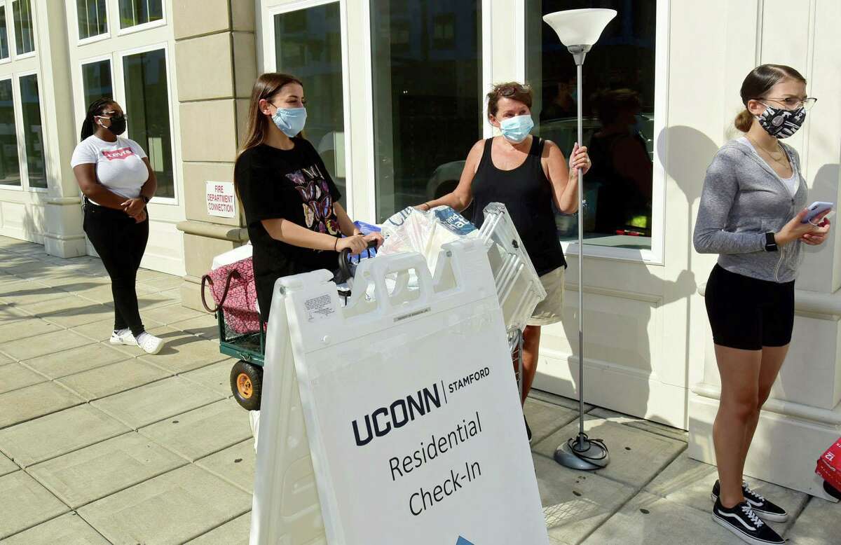 About 265 Stamford UCONN students including freshman Sophia Magrone accompanied by her mom, Mary Jo Magrone, of Bethel, center, move into the 900 Washington BLVD residence hall Friday, August 14, 2020, in Stamford, Conn. Students received specific arrival times to help stagger the amount of people in each building at any particular time as part of a COVID protocol. About 5,500 students will be moving into Storrs residence halls Friday through Monday.