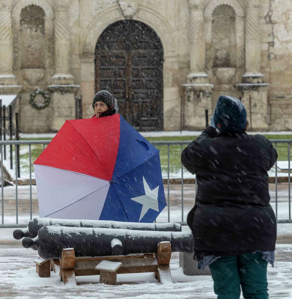 Ruth Madorsky takes a picture Thursday, Feb. 18, 2021, in front of the Alamo as snow returns to San Antonio.