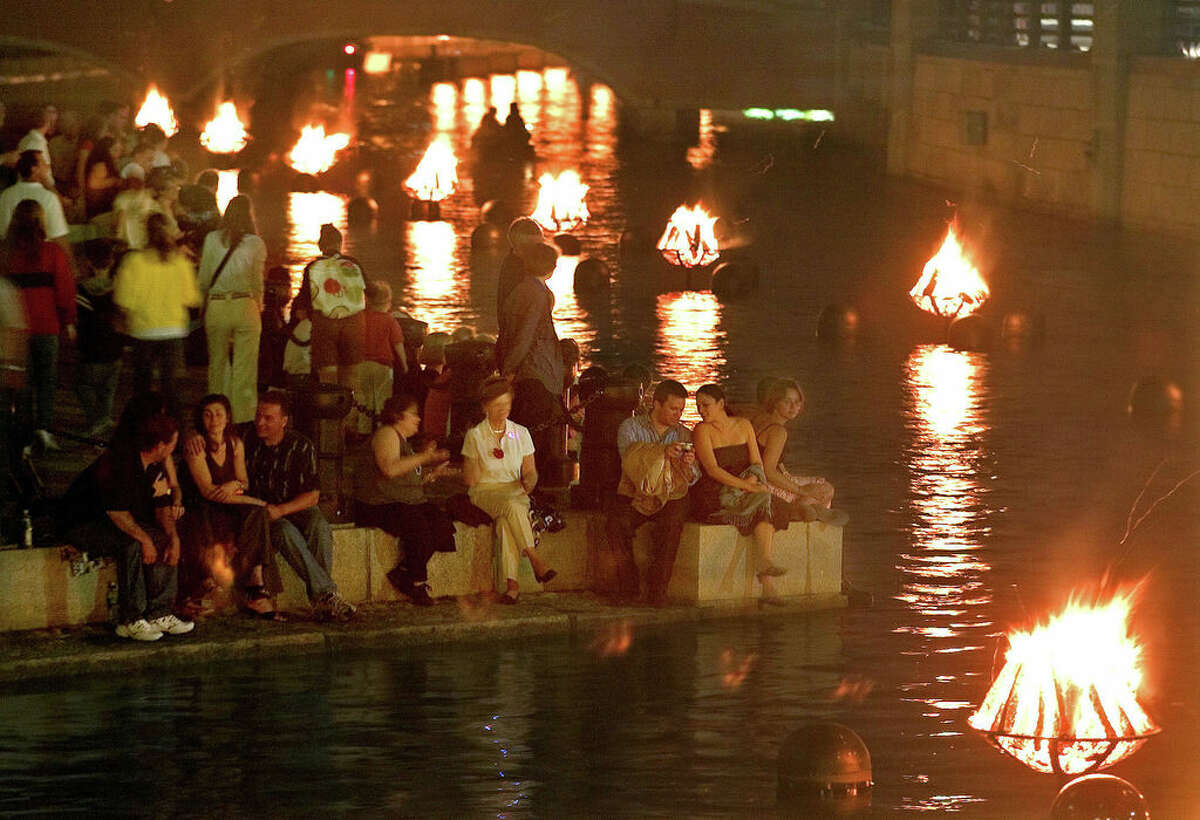 Crowds gather along the riverfront in 2006 to watch the WaterFire art installation in Providence, Rhode Island. The work by Barnaby Evans centers on a series of 100 bonfires that blaze just above the surface of the three rivers that pass through the middle of downtown Providence. (Stew Milne/The Associated Press)