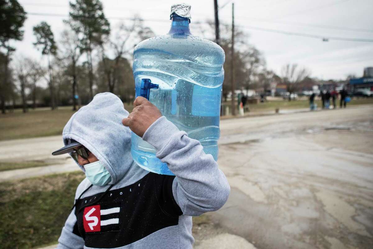 Luis Martinez carries a full water container to his car after filling it from a spigot in Haden Park Thursday, Feb. 18, 2021 in Houston. Houston and several surrounding communities are under a boil water notice as many residents are still without running water in their homes, despite power returning to the region.