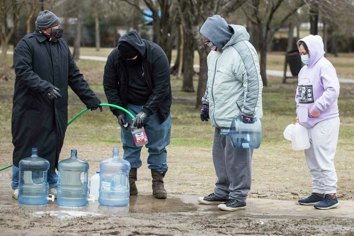 People line up to fill containers of various sizes from a spigot at Haden Park Thursday, Feb. 18, 2021 in Houston. Houston and several surrounding communities are under a boil water notice as many residents are still without running water in their homes, despite power returning to the region.