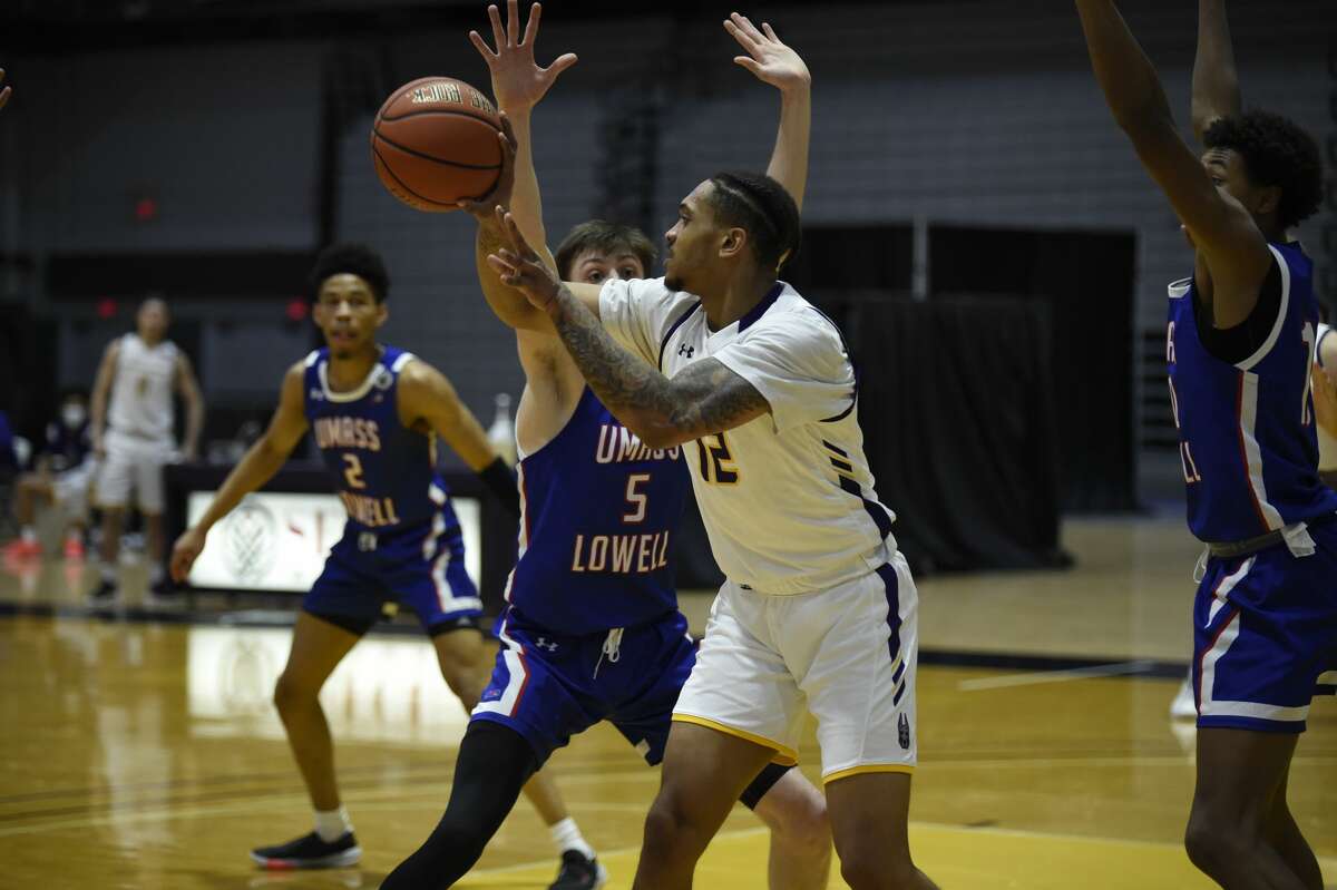 UAlbany senior forward Kellon Taylor looks to pass against UMass-Lowell defenders (from left) Kalil Thomas, Connor Withers and Max Brooks in an America East basketball game Friday, Feb. 12, 2021, at SEFCU Arena in Albany. (Kathleen Helman/UAlbany athletics)