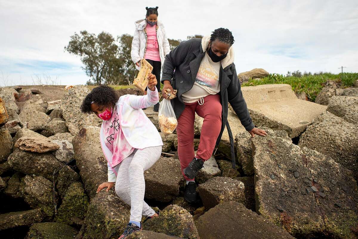 Felicia Carter walks to the beach in Rodeo with her granddaughters, Aubreyona and Daeshanay Gospel. Carter lost her hotel job in March and her unemployment benefits in December.