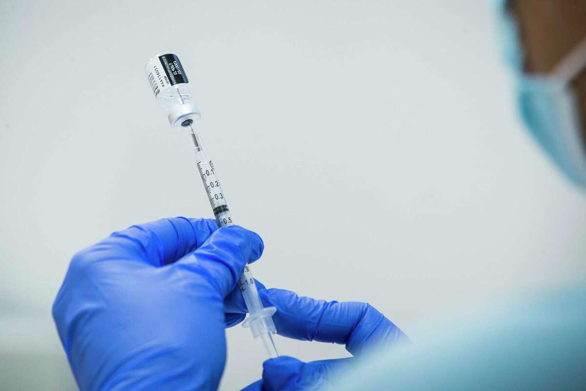 Sochi Evans, pharmacy technician, fills a syringe with Pfizer-BioNTech Covid-19 vaccine at Texas Southern University Thursday, Feb. 11, 2021 in Houston.