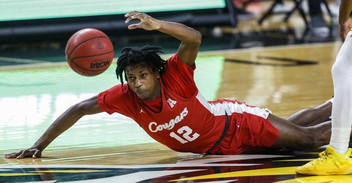 Houston's Tramon Mark falls to court while the chasing the ball next to Wichita State's Ricky Council, right, during the first half of an NCAA college basketball game Thursday, Feb. 18, 2021, in Wichita, Kan. (Travis Heying/The Wichita Eagle via AP)