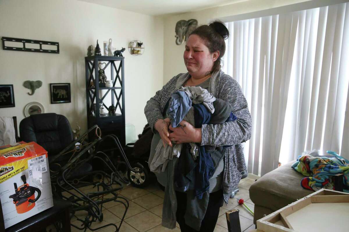 At the thought of losing mostly everything she owned, Brandy Robinson, 36, breaks down in the living room of her Seven Oaks Apartments unit, on Feb. 18, 2021. Her unit flooded after a water pipe to the water heater burst on Monday during the extreme cold spell. After two days of living in the flooded unit, she rented a room at the Best Western Hotel off Loop 410. With only Social Security and food stamps, she is pleading with friends for help in paying for the hotel room and is not sure how much longer they can stay.