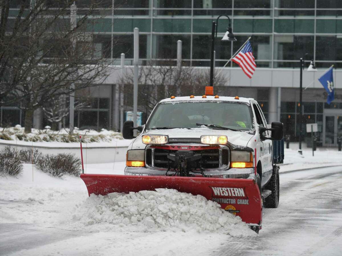 A plow clears snow at Harbor Point in Stamford, Conn. Thursday, Feb. 18, 2021. The area received a blanketing of snow starting Thursday morning that is expected to last into Friday.