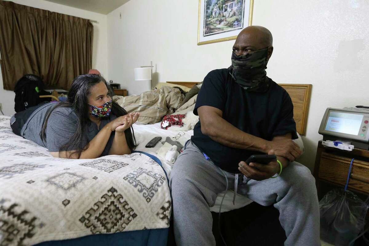 Eddie Palmer sits with his wife, Ginette, while he undergoes peritoneal dialysis in a motel on Wednesday, Feb. 18, 2021.