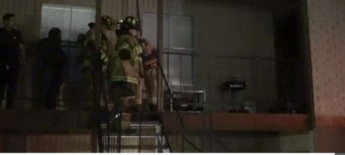 Firefighters extinguish a blaze started when residents at a west Houston apartment used a charcoal grill to keep warm on Friday, Feb. 19, 2021.