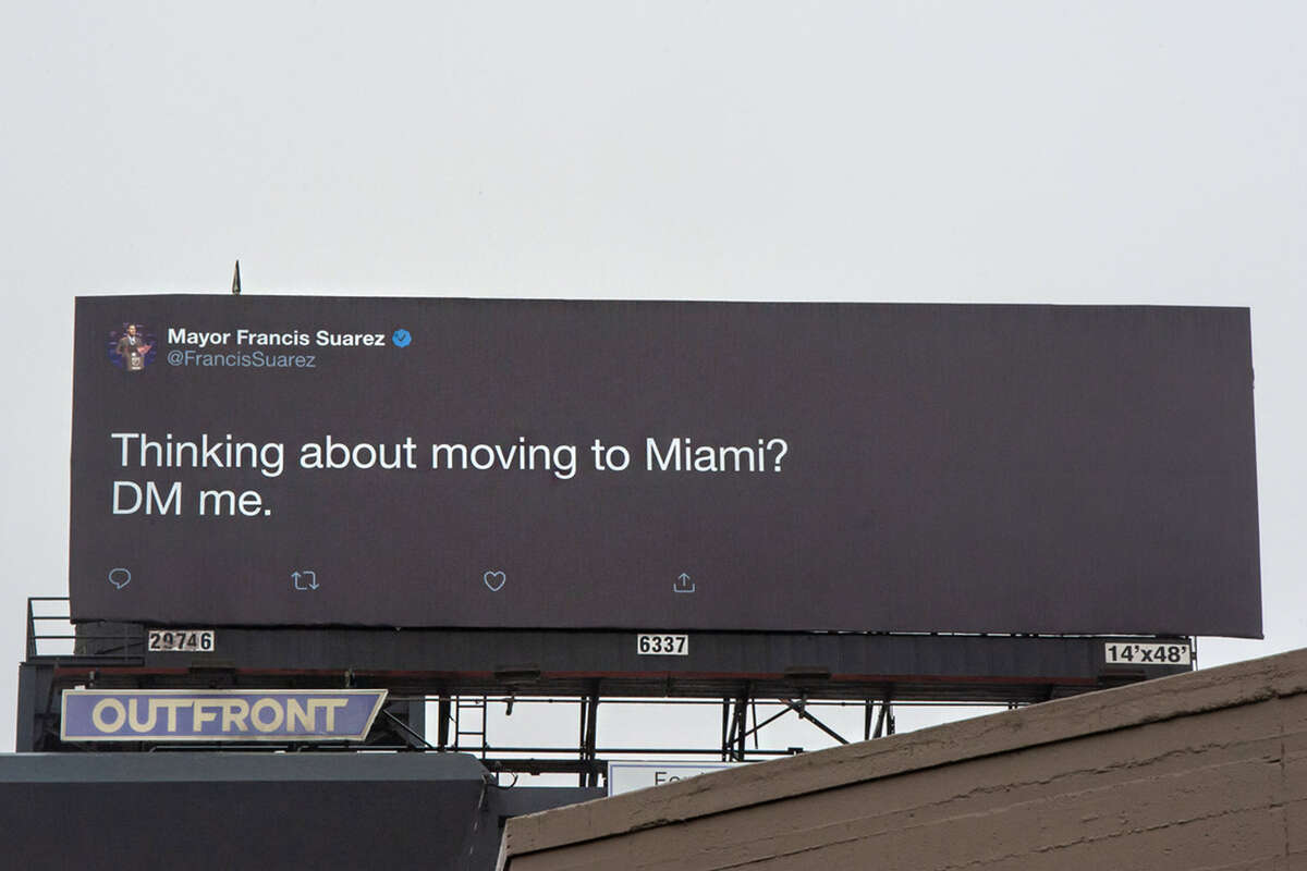 Right off the Ninth Street and Civic Center exit on U.S. Highway 101, a billboard shows a clear message from Francis Suarez, the mayor of Miami. "Thinking about moving to Miami?" the billboard reads. "DM me."