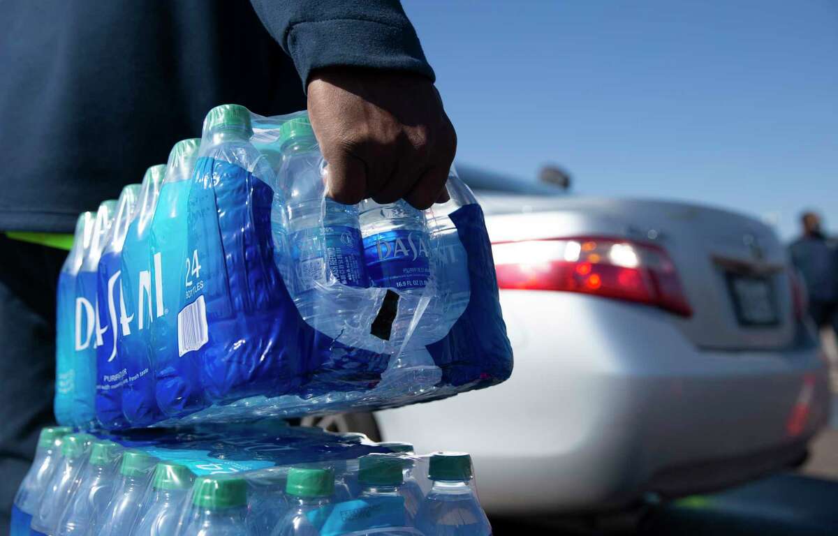 Volunteers help distributing free bottled water at a mass distribution Friday, Feb. 19, 2021, at Delmar Stadium in Houston. The city is still under boil water order and some places are still having low water pressure.