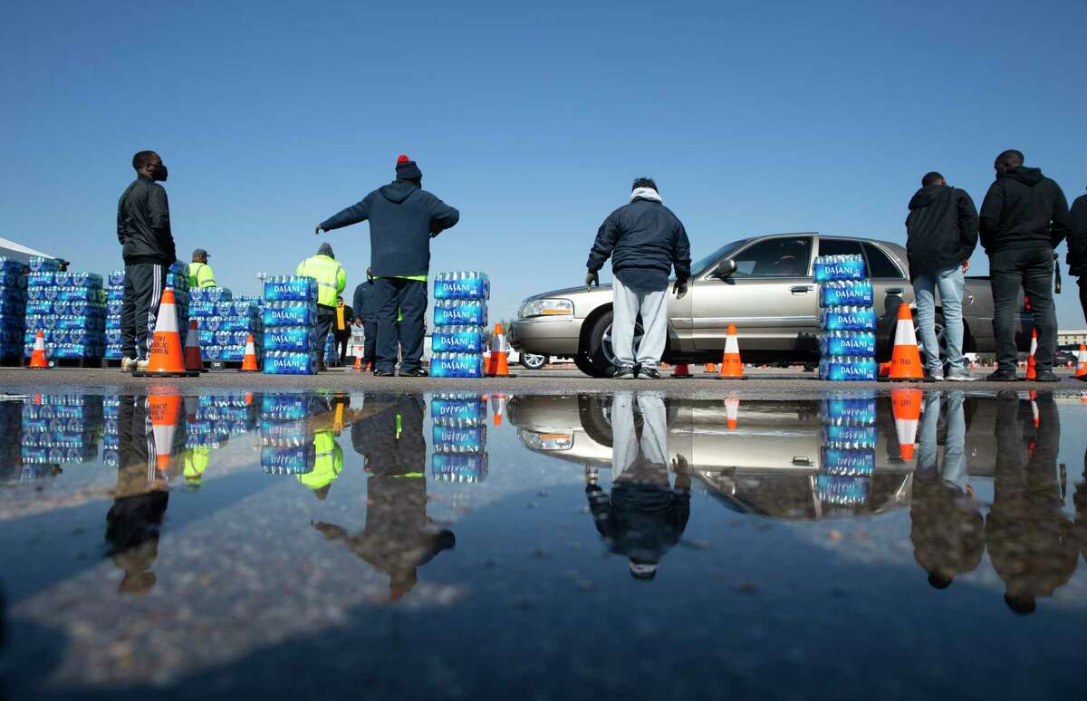 Volunteers from Texas Southern University help distributing free bottled water at a mass distribution Friday, Feb. 19, 2021, at Delmar Stadium in Houston. The city is still under boil water order and some places are still having low water pressure.
